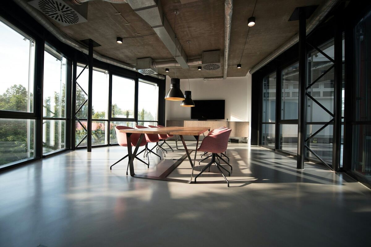 A bright meeting room with a long table and tall windows